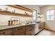 Neutral kitchen with tile backsplash, stainless steel sink, wood cabinets, and open shelving with LED lighting at 8082 Abington Way, Zionsville, IN 46077