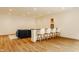 Bright living room featuring wood flooring, a cozy seating area with blue sofa and a bar with seating for four at 8082 Abington Way, Zionsville, IN 46077