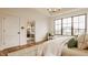 Bright main bedroom showcases an ensuite bath and large windows offering picturesque outdoor views, complemented by neutral decor at 8082 Abington Way, Zionsville, IN 46077