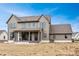 Rear exterior featuring a covered patio and a new concrete patio surrounded by a large, unfinished backyard at 8082 Abington Way, Zionsville, IN 46077