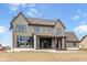 Rear exterior featuring a covered patio and a new concrete patio surrounded by a large, unfinished backyard at 8082 Abington Way, Zionsville, IN 46077
