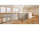 Open-concept staircase showcasing modern railing, hardwood floors, large windows, and an abundance of natural light at 8082 Abington Way, Zionsville, IN 46077