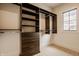 Walk-in closet featuring custom dark wood shelving, drawers, and ample storage space, combining functionality with modern style at 8082 Abington Way, Zionsville, IN 46077
