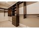 This walk-in closet offers dark wood shelves, drawers, ample storage space, and stylish design for organized convenience at 8082 Abington Way, Zionsville, IN 46077