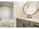 Modern bathroom featuring gray vanity, quartz countertop, round mirror, and tiled shower with rainfall shower head at 8092 Abington Way, Zionsville, IN 46077