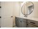 Modern bathroom featuring a gray vanity with a white countertop and a circular mirror at 8092 Abington Way, Zionsville, IN 46077