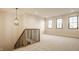 Spacious bonus room with plush carpet, large windows, and stylish pendant lighting at 8092 Abington Way, Zionsville, IN 46077