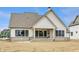 View of the back of the house, featuring a covered patio and white vertical siding at 8092 Abington Way, Zionsville, IN 46077