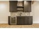 Stylish wet bar featuring sleek dark cabinets, herringbone backsplash, and a stainless steel beverage cooler at 8092 Abington Way, Zionsville, IN 46077