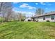 Spacious backyard with lush green grass, mature trees, and a charming patio area at 8110 Madrone Ct, Indianapolis, IN 46236