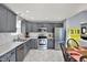 Well-lit kitchen featuring stainless steel appliances, gray cabinets, modern countertops, and eat-in dining area at 8110 Madrone Ct, Indianapolis, IN 46236