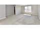 A bright bedroom featuring neutral carpeting, grey walls, and a window that allows natural light to illuminate the space at 8163 Dewberry Ln, Pendleton, IN 46064
