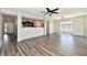 Well-lit living room with wood floors, open layout to kitchen and entryway, and modern ceiling fan at 8163 Dewberry Ln, Pendleton, IN 46064