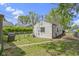 View of a backyard featuring a grill, chain-link fence, grass, and partial view of the home's exterior at 819 E Mills Ave, Indianapolis, IN 46227