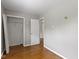 Bedroom with hardwood floors, neutral paint, and an open closet at 819 E Mills Ave, Indianapolis, IN 46227