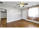 A bright, empty bedroom featuring hardwood floors, a ceiling fan, and neutral paint, offering versatility at 819 E Mills Ave, Indianapolis, IN 46227