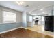 Open dining area with hardwood floors and views into a modern kitchen with white cabinetry and appliances at 819 E Mills Ave, Indianapolis, IN 46227