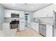 An updated kitchen design with stainless appliances, white cabinets, and view to a laundry area at 819 E Mills Ave, Indianapolis, IN 46227