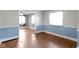 A traditional living room showcasing attractive hardwood floors, two windows, and blue wainscoting on the walls at 819 E Mills Ave, Indianapolis, IN 46227