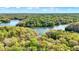 Breathtaking aerial view of a lake surrounded by lush green forest on a sunny day with scattered clouds at 8191 S Bayview Ct, Trafalgar, IN 46181
