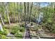 Backyard view featuring a wooden walkway leading down to the lake and firepit with seating at 8191 S Bayview Ct, Trafalgar, IN 46181