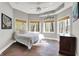 Bright bedroom boasts a tray ceiling, multiple windows offering a view, and stone tile floors at 8191 S Bayview Ct, Trafalgar, IN 46181