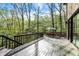 Deck with wood railing features an outdoor table and seating area with wooded landscape at 8191 S Bayview Ct, Trafalgar, IN 46181