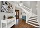 Grand foyer featuring dark hardwood floors, white staircase, and elegant chandelier at 8191 S Bayview Ct, Trafalgar, IN 46181
