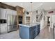 Open kitchen features stainless appliances, center island, brick accent wall and white staircase at 8191 S Bayview Ct, Trafalgar, IN 46181