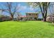 A spacious backyard featuring a well-manicured lawn, stone patio, and a two-story home with a stone facade at 8332 Tanager Ln, Indianapolis, IN 46256