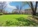 Expansive green backyard featuring a well-kept lawn, patio area, mature trees, and partial view of the house at 8332 Tanager Ln, Indianapolis, IN 46256