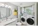 Well-lit bathroom featuring modern washer and dryer, and a sleek vanity at 8332 Tanager Ln, Indianapolis, IN 46256