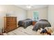 Comfortable bedroom with two twin beds, a window with bright daylight and wood floors at 8332 Tanager Ln, Indianapolis, IN 46256