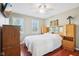 Comfortable bedroom featuring a ceiling fan, windows, and beautiful wooden furniture at 8332 Tanager Ln, Indianapolis, IN 46256