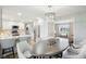 Well-lit dining area adjacent to a white kitchen with stainless steel appliances at 8332 Tanager Ln, Indianapolis, IN 46256