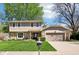 Charming two-story home with a manicured lawn, stone accents, and an attached two-car garage at 8332 Tanager Ln, Indianapolis, IN 46256