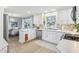 Well-lit kitchen with stainless steel appliances, light wood floors, white cabinets, and view to dining area at 8332 Tanager Ln, Indianapolis, IN 46256