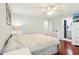 Cozy main bedroom with hardwood floors, ceiling fan, a well-lit vanity, and a full ensuite bathroom at 8332 Tanager Ln, Indianapolis, IN 46256
