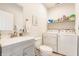 Functional laundry bathroom featuring a sink vanity, toilet, and a side-by-side washer and dryer set at 926 Olive St, Indianapolis, IN 46203