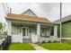Charming home with a inviting front porch, featuring a cozy seating area and decorative hanging plants at 926 Olive St, Indianapolis, IN 46203