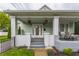 Charming home with a inviting front porch, featuring a cozy seating area and decorative hanging plants at 926 Olive St, Indianapolis, IN 46203