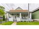 Charming home with a inviting front porch, featuring a cozy seating area and decorative hanging plants at 926 Olive St, Indianapolis, IN 46203