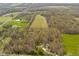 Aerial view of land parcel featuring a house, outbuildings, wooded area, and expansive open field at 9570 S 300 W, Columbus, IN 47201
