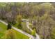 Elevated view of a home, garage, and shed with verdant trees along a paved road at 9570 S 300 W, Columbus, IN 47201