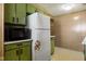 Vintage kitchen features olive-green cabinets, a microwave, and a white refrigerator at 9570 S 300 W, Columbus, IN 47201
