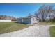 Exterior shot of home showcasing blue siding, well-maintained grounds, and gravel driveway at 1004 Shepherd Rd, Anderson, IN 46012