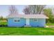 Charming single-story home featuring blue siding, a well-kept lawn, and mature trees at 1004 Shepherd Rd, Anderson, IN 46012