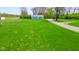 An exterior view of the home from the side yard showcasing ample greenery at 1004 Shepherd Rd, Anderson, IN 46012