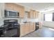 Functional kitchen with light cabinetry, black appliances, and tile backsplash at 1004 Shepherd Rd, Anderson, IN 46012