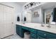 Bathroom featuring teal vanity with white countertop, stool, and large mirror with stylish modern lighting at 1032 Grovewood Dr # 0, Beech Grove, IN 46107
